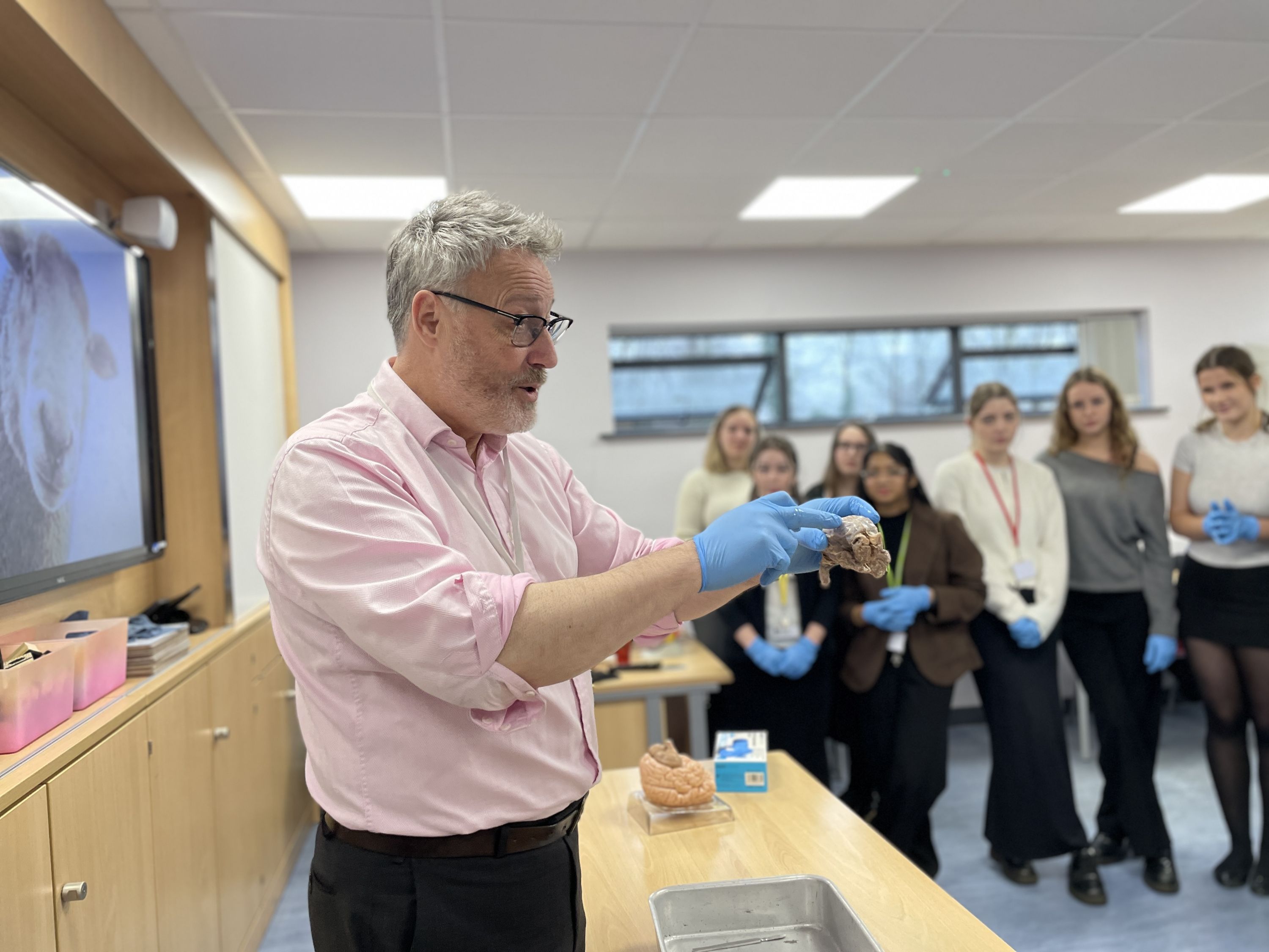 Photo of Dr Guy Sutton holding a sheep's brain